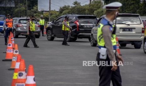 Petugas gabungan mengatur lalu lintas saat pemberlakuan ganjil genap di gerbang keluar Tol Pasteur, Kota Bandung.