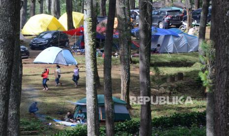 Pengunjung menikmati awal tahun baru setelah sebelumnya menikmati malam pergantian tahun dengan kemping, di Camping Ground kawasan hutan pinus Cikole, Kecamatan Lembang, Kabupaten Bandung Barat, Sabtu (1/1). Melewati malam pergantian tahun dengan kemping di alam terbuka, saat ini banyak diminati masyarakat. Selain menyenangkan, juga dianggap relatif aman di masa pandemi Covid-19.