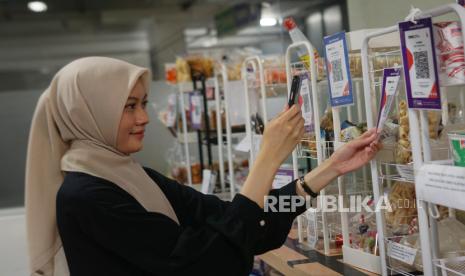 Karyawan melakukan pembayaran menggunakan QRIS di salah satu merchant kantin karyawan PT Bank Muamalat Indonesia Tbk di Jakarta, Rabu (7/2/2024). Bank Muamalat sebagai QRIS acquirer memfasilitasi nasabah yang memiliki usaha, khususnya yang bergerak di sektor usaha mikro, kecil dan menengah agar semakin mudah dalam mengelola transaksi pembayaran usahanya. Nasabah dibekali aplikasi Muamalat Merchant App (MMA) yang dapat diunduh di toko aplikasi Playstore dan Appstore. Per 31 Desember 2023, jumlah merchant QRIS yang terdaftar di Bank Muamalat sebanyak 9.488, meningkat lima kali lipat.                               