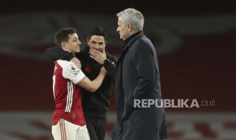 Manajer Arsenal Mikel Arteta menyapa Cedric Soares dari Arsenal ketika manajer Tottenham Jose Mourinho lewat setelah pertandingan sepak bola Liga Premier Inggris antara Arsenal dan Tottenham Hotspur di Stadion Emirates di London, Inggris, Minggu, 14 Maret 2021. (