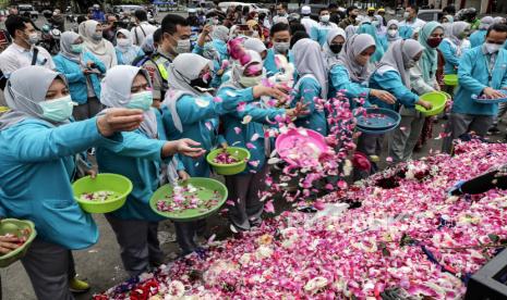 Paramedis melemparkan bunga saat memberikan belasungkawa kepada para korban kerusuhan dan penyerbuan pertandingan sepak bola di luar Stadion Kanjuruhan di Malang, Jawa Timur, 03 Oktober 2022. Menkes Budi Gunadi mengatakan perawatan korban tragedi Kanjuruhan jadi prioritas.