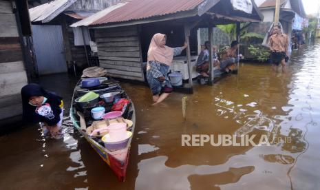 477 Korban Banjir Banjarmasin Mengungsi di Terminal. Orang-orang berbicara di luar rumah mereka di lingkungan yang terkena dampak banjir di Banjarmasin, Kalimantan Selatan di Pulau Kalimantan, Indonesia, Minggu, 17 Januari 2021. ribuan orang telah dievakuasi dan beberapa telah tewas dalam beberapa hari terakhir akibat banjir di Indonesia. Pulau Kalimantan, kata para pejabat Minggu.