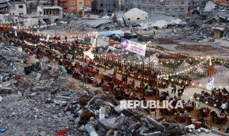 Warga Palestina berbuka puasa bersama diantara reruntuhan rumah dan bangunan di Rafah, Jalur Gaza selatan, Sabtu (1/3/2025). Pasca gencatan senjata, warga Palestina menjalani bulan suci Ramadhan dengan lebih baik jika dibandingkan tahun sebelumnya. Meski hidup ditengah kondisi kota yang hancur, namun pada Ramadhan tahun ini warga Palestina di Gaza bisa melakukan buka puasa dan ibadah Ramadhan bersama dengan tenang. 