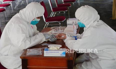 Pemerintah Provinsi DKI Jakarta menerapkan rapid test menggunakan serum sebagai proses deteksi dini massal yang menyasar masyarakat berisiko tinggi tertular Covid-19. [Foto: Ilustrasi petugas mengambil sampel darah sesama petugas].