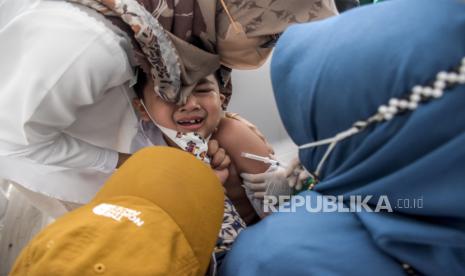 Vaksinator menyuntikkan vaksin Covid-19 ke siswa Sekolah Dasar (SD) saat pelaksanaan vaksinasi Covid-19 bagi anak usia 6-11 tahun. 