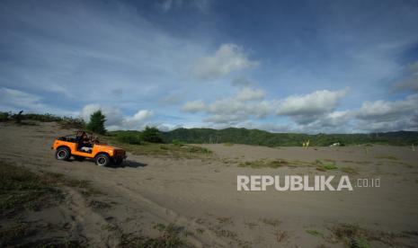 Wisatawan naik kendaraan jip melintasi kawasan wisata Gumuk Pasir, Parangkusumo, Bantul, D.I Yogyakarta, Senin (24/1/2022). Gumuk Pasir yang berada di pesisisr selatam Yogyakarta tersebut merupakan salah satu destinasi wisata alam andalan di Kabupaten Bantul. 