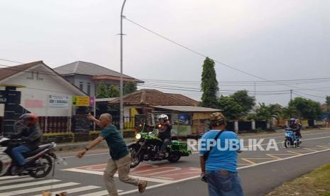 Sejumlah warga dan santri mencoba menghentikan rombongan moge Harley Davidson yang melintas di Jalan Nasional, Kecamatan Cihaurbeuti, Kabupaten Ciamis, Sabtu (27/5/2023). Seorang santri Pondok Pesantren Miftahul Huda Al Abidin diduga menjadi korban tabrak lari rombongan moge. 