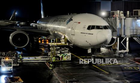 Petugas menurunkan barang bawaan jamaah haji dari pesawat saat  tiba di Terminal 2F Bandara Soekarno Hatta, Tangerang, Banten, Sabtu (16/7/2022) dini hari. Penerbangan Jamaah Haji dengan Garuda Kembali Tertunda Hingga 12 Jam