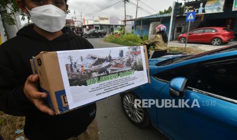 Relawan mengumpulkan donasi dari pengendara yang melintas di Palu, Sulawesi Tengah, Jumat (15/1/2021). Relawan maupun lembaga kemanusian di daerah tersebut mulai melakukan penggalangan dana untuk memberikan bantuan bagi korban gempa di Mamuju, Sulawesi Barat. 