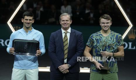 Holger Rune dari Denmark, kanan, memegang trofi setelah mengalahkan petenis Serbia Novak Djokovic, kiri, saat mantan petenis Swedia Stefan Edberg, tengah, berpose, setelah final Paris Masters di Accor Arena, Ahad, 6 November 2022 di Paris . Rune menang 3-6, 6-3, 7-5.