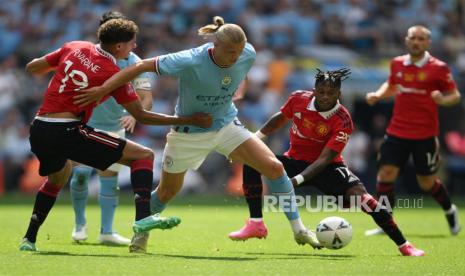  Striker Man City Erling Haaland (tengah) diadang 2 pemain MU, Varane (kiri) dan Fred dalam final Piala FA, di London, Inggris, Sabtu (3/6/2023).