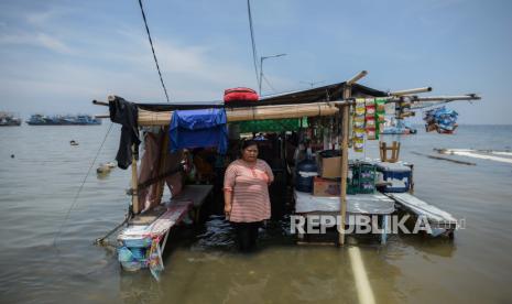 Warga beraktivitas di kawasan yang terdampak banjir rob di Pelabuhan Kali Adem, Jakarta, Rabu (21/10). Ketinggian air yang mencapai  30 cm hingga 60 cm merendam kawasan tersebut sejak Senin  (19/10) pagi akibat air laut pasang, menurut warga banjir rob kali ini merupakan banjir yang paling parah dibandingkan tahun sebelumnya. Republika/Thoudy Badai