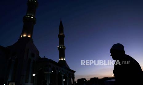  Seorang Muslim pergi untuk melakukan sholat maghrib setelah berbuka puasa setelah matahari terbenam pada bulan suci Ramadhan, di luar Masjid Al Farooq di Teluk Emirat Dubai, Uni Emirat Arab, Selasa (4 /4/2023). Idul Fitri 2023: Umat Muslim di UEA Diminta Bantu Cari Bulan Sabit Besok