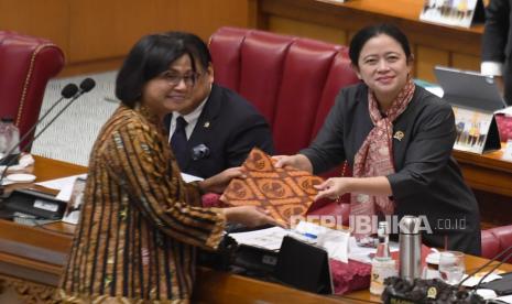 Menteri Keuangan Sri Mulyani Indrawati (kiri) menyerahkan berkas pendapat akhir presiden terkait pembahasan Rancangan Undang-Undang (RUU) tentang Pengembangan dan Penguatan Sektor Keuangan (PPSK) kepada Ketua DPR Puan Maharani saat rapat paripurna di Kompleks Parlemen, Senayan, Jakarta, Kamis (15/12/2022). RUU P2SK telah disahkan oleh presiden menjadi Undang-Undang (UU) Nomor 4 Tahun 2023 (UU Nomor 4/2023)