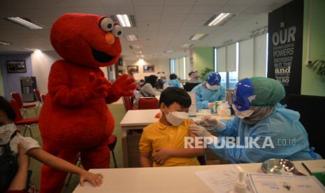 Tenaga kesehatan menggunakan topeng pahlawan super (superhero) saat melayani vaksinasi anak usia 6-11 tahun bagi anak pegawai Otoritas Jasa Keuangan (OJK)di Gedung OJK, Wisma Mulia, Jakarta, Ahad (16/1/2022). Sebanyak 350 anak pegawi OJK mengikuti vaksinasi covid-19 dosis kedua menggunakan vaksin Sinovac. Penggunaan topeng superhero tersebut sebagai upaya menarik minat anak untuk mengikuti vaksinasi Covid-19. Republika/Thoudy Badai