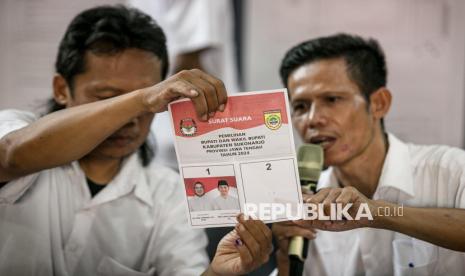 Petugas KPPS menunjukkan surat suara pemilihan Bupati dan Wakil Bupati Sukoharjo saat proses penghitungan suara Pilkada 2024 di TPS 02 Mendungan, Kartasura, Sukoharjo, Jawa Tengah, Rabu (27/11/2024).