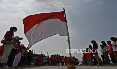 Sejumlah anak dan relawan komunitas Kelas Jurnalis Cilik mengikuti upacara bendera dalam rangka hari ulang tahun (HUT) ke-77 Republik Indonesia di pesisir Cilincing, Jakarta, Rabu (17/8/2022). Upacara tersebut digelar untuk menumbuhkan kecintaan anak-anak pesisir Jakarta terhadap Tanah Air sekaligus menumbuhkan semangat menjaga kelestarian lingkungan setempat. 