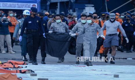 Tim SAR Bakamla RI menyerahkan kantong yang berisi bagian tubuh dan puing-puing pesawat Sriwijaya Air nomor penerbangan SJ182 rute Jakarta-Pontianak pada hari kelima operasi SAR di Dermaga JICT, Tanjung Priok, Jakarta, Rabu (13/1). 