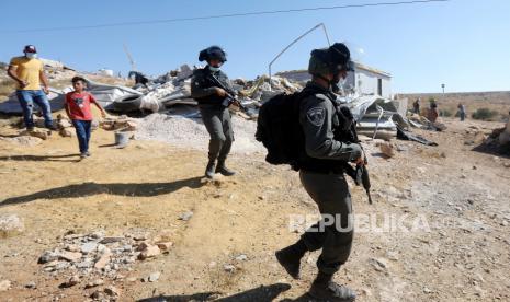  Polisi perbatasan Israel berjaga-jaga ketika buldoser menghancurkan sebuah rumah di daerah Tepi Barat Masafer, dekat Yatta, 06 Agustus 2020. Masafer Yatta, koleksi 19 dusun Palestina digolongkan sebagai Area C, yang berada di bawah kendali Israel, sejalan dengan Persetujuan Oslo II. Rumah-rumah itu hancur setelah penyewa Palestina mereka tidak memberikan izin yang dibutuhkan Israel untuk membangun infrastruktur di daerah tersebut.