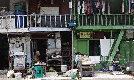 Warga duduk di depan rumahnya di kawasan kumuh Tanah Abang, Jakarta Pusat pada 17 Oktober 2022.