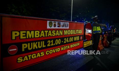 Polisi mengatur lalu lintas saat penutupan ruas Jalan Jenderal Sudirman, Kota Bogor, Jawa Barat, Senin (5/5) malam. penutupan tersebut dilakukan untuk membatasi mobilitas warga di malam hari pada masa Pemberlakukan Pembatasan Kegiatan Masyarakat (PPKM) Darurat untuk mengurangi penyebaran virus Covid-19. Republika/Putra M. Akbar