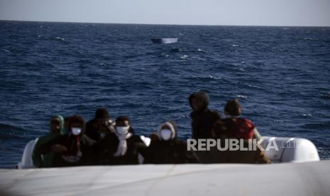  Para migran, kebanyakan dari mereka dari Eritrea, dibantu oleh pekerja bantuan dari LSM Spanyol Open Arms, setelah melarikan diri dari Libya dengan kapal kayu berbahaya di laut Mediterania, sekitar 110 mil utara Libya, pada Sabtu, 2 Januari 2021.