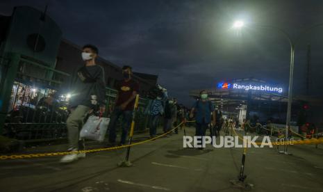 Penumpang berjalan menuju kereta api di Stasiun Rangkasbitung, Lebak, Banten.