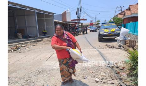 Warga Desa Dadap, Kecamatan Juntinyuat, Kabupaten Indramayu, membawa pulang beras program bantuan pangan cadangan beras pemerintah (CBP) tahap dua, Selasa (19/9/2023). 