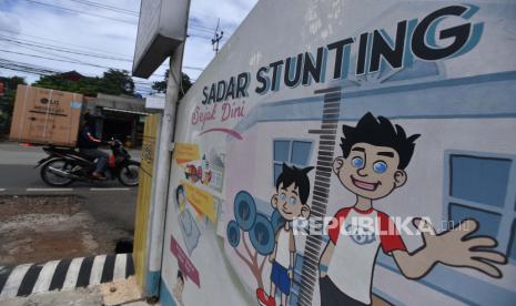 Pengendara motor melintas di dekat mural stunting di Jakarta, beberapa waktu lalu. Kemenko PMK menyatakan berdasarkan data saat ini angka stunting di Indonesia masih sebesar 27,9 persen, sementara target angka stunting yang dicanangkan Presiden Joko Widodo sebesar 14 persen pada 2024. 