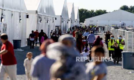 Pengungsi Afghanistan berjalan melalui sebuah kamp pengungsi di Pangkalan Bersama McGuire Dix Lakehurst, New Jersey, AS, Senin, 27 September 2021. Kamp tersebut saat ini menampung sekitar 9.400 pengungsi Afghanistan dan memiliki daya tampung hingga 13.000 orang. Meski Didera Derita, Pengungsi Afghanistan Sambut Ramadhan di AS dengan Syukur