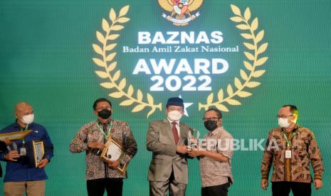 Ketua Badan Amil Zakat Nasional (BAZNAS) RI KH. Noor Achmad memberikan pengahargaan kepada Wakil Pemimpin Redaksi Republika Nur Hasan Murtiaji dalam acara Baznas Award 2022 di Jakarta, Senin (17/1/2022). Republika mendapatkan pengargaan Baznas Award 2022 Ketegori Media Pendukung Gerakan Zakat Indonesia pada Media Cetak.Prayogi/Republika