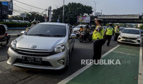 Anggota kepolisian menghentikan kendaraan di kawasan Fatmawati, Jakarta, Senin (10/8). Direktorat Lalu Lintas Polda Metro Jaya kembali menerapkan sanksi tilang terhadap kendaraan roda empat yang melanggar peraturan ganjil genap di masa Pembatasan Sosial Berskala Besar (PSBB) transisi. Republika/Putra M. Akbar