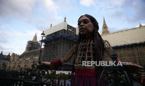 Little Amal berdiri dengan latar belakang Elizabeth Tower, yang dikenal sebagai Big Ben, di sebelah kiri, dan Gedung Parlemen di London, Senin, 25 Oktober 2021.