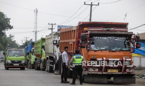 Polisi dan Petugas Dishub mencegat truk yang akan melintas di Jalan Sudamanik, Parung Panjang. Polisi memutar balik truk tambang yang melintasi Parung Panjang sebelum waktunya.