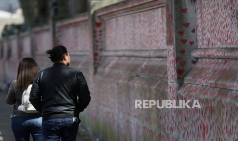  Warga berjalan melewati National Covid Memorial Wall di London, Selasa, 27 April 2021. Inggris 