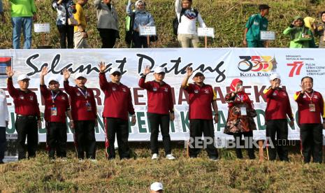 Ketua Asosiasi Pemerintah Kota Seluruh Indonesia (Apeksi) yang juga Wali Kota Bogor Bima Arya (tengah) bersama para wali kota dari berbagai daerah melambaikan tangan usai menanam pohon durian di kebun buah Dinas Pertanian, Sungai Lareh, Padang, Sumatera Barat, Senin (8/8/2022). Penamanan pohon durian oleh 85 wali kota se-Indonesia itu merupakan rangkaian kegiatan Rakernas Apeksi XV Tahun 2022 yang mengangkat tema “Menuju Indonesia Tangguh”. 