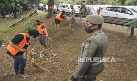 Petugas gabungan memberikan sanksi kerja sosial kepada warga yang tidak menggunakan masker di Simpang UI, Perbatasan Kota Depok - Jakarta, Sabtu (5/9/2020). Operasi masker tersebut dilakukan oleh petugas gabungan Jawa Barat dengan DKI Jakarta sebagai bentuk pengawasan dan penindakan bagi pelanggar protokol kesehatan COVID-19.