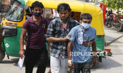 Pasien Covid-19 dibawa oleh kerabatnya di luar rumah sakit pemerintah Covid-19, Ahmedabad, India, Selasa (27/4). Kasus Covid-19 di India melonjak lebih cepat daripada di tempat lain di dunia. Tercatat angka kematian di India akibat virus Covid-19 telah mencapai 200 ribu jiwa. (AP Photo/Ajit Solanki)