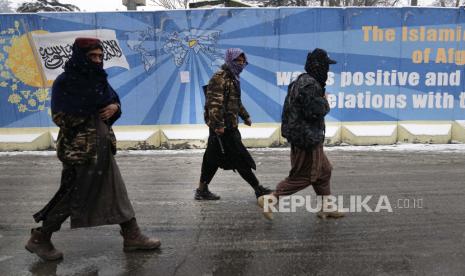 Pejuang Taliban berjalan di jalan dekat kementerian luar negeri Afghanistan, di Kabul, Afghanistan, Ahad, 6 Februari 2022.