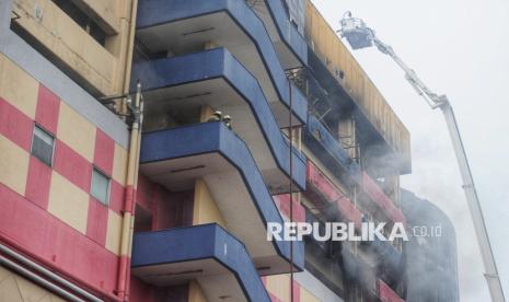 Petugas pemadam kebakaran melakukan proses pendinginan setelah terjadi kebakaran di Glodok Plaza, Jakarta, Kamis (16/1/2025). 