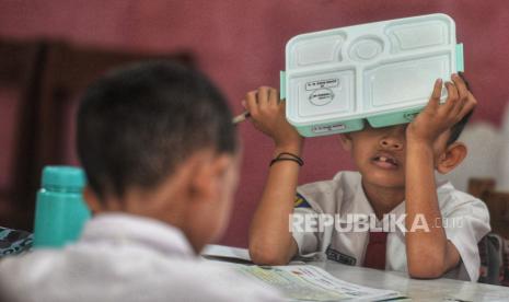 Para siswa memegang kotak makanan saat ujicoba pelaksanaan program Makan Bergizi Gratis (MBG) di SDN 4  Kota Tangerang, Banten, Senin (5/8/2024). Uji coba MBG tersebut bertujuan mematangkan strategi dan mitigasi program unggulan Presiden dan Wakil Presiden Terpilih periode 2024-2029. Adapun paket menu yang disediakan hari ini adalah Nasi Putih, Fuyunghai, Capcay, Melon dan Susu.