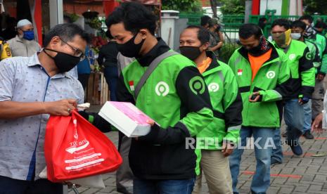 Sejumlah pengemudi ojek daring antre untuk mendapatkan bantuan paket sembako. ilustrasi