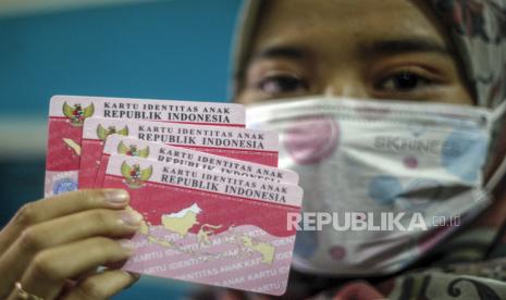 Petugas Disdukcapil Kabupaten Bogor menunjukkan Kartu Identitas Anak (KIA) yang selesai dicetak  di kantor Disdukcapil, Cibinong, Kabupaten Bogor, Jawa Barat, Selasa (14/7/2020). Disdukcapil Kabupaten Bogor menargetkan pembuatan KIA dengan sistem daring sebanyak 80 keping per hari selama pandemi COVID-19. 