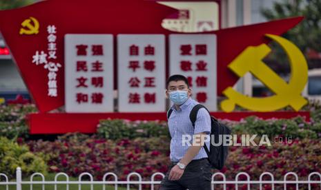 Pria yang mengenakan masker berjalan di stasiun kereta api di Shanghai, Cina, 29 Juli 2021. 