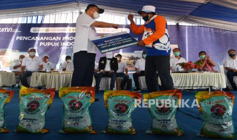 Direktur Utama PT Pupuk Indonesia (Persero) Ahmad Bakir Pasaman (kiri) memberikan bantuan pupuk kepada seorang perwakilan petani saat Pencananan Program Nasional Agro Solution PT Pupuk Indonesia (Persero) di Jember, Jawa Timur, Kamis (5/11/2020). Program yang bertujuan meningkatkan produktivitas dan mengurangi ketergantungan petani terhadap pupuk bersubsidi tersebut diharapkan dapat diterapkan di seluruh Indonesia. 