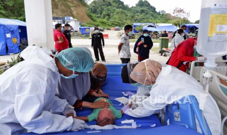 Seorang anak menerima perawatan medis di lorong pintu masuk rumah sakit saat pasien dirawat di luar di tengah kekhawatiran gempa susulan di rumah sakit yang terkena dampak gempa bumi di Mamuju, Sulawesi Barat.