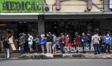 Sejumlah warga mengantre untuk membeli masker dan cairan antiseptik pembersih tangan di salah satu pusat penjualan Alat Kesehatan dan Kedokteran di Jalan Suniaraja, Kota Bandung, Ahad (22/3).