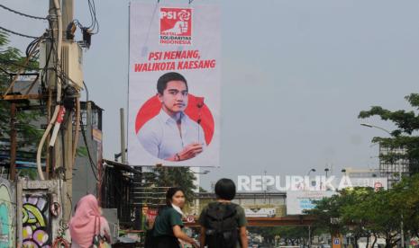 Warga berjalan di dekat baliho bergambar putra Presiden Joko Widodo, Kaesang Pangarep di Jalan Margonda Raya, Kota Depok, Jawa Barat, Selasa (23/5/2023). Baliho yang dipasang oleh Partai Solidaritas Indonesia (PSI) Kota Depok itu untuk memperkenalkan sosok Kaesang kepada warga yang nantinya akan diusung oleh partai tersebut pada Pilkada 2024.