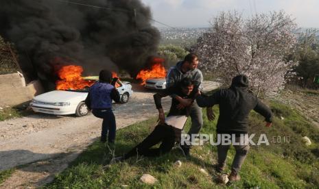 File - Warga Palestina membantu seorang pemuda yang terluka dalam bentrokan dengan pemukim Israel di Tepi Barat, pada 25 Februari 2023. 