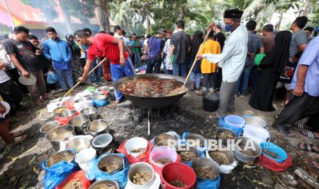 Warga antre mengambil menu kuliner tradisional kuah beulangong daging sapi pada perayaan kenduri Nuzulul Quran di Desa Doy Ulee Kareng, Banda Aceh, Aceh, Senin (17/3/2025). Menu kuliner tradisional khas Aceh kuah beulangong yang dimasak secara gotong royong untuk sajian berbuka puasa pada peringatan Nuzulul Quran 1446 Hijriah itu telah menjadi tradisi dan dibagikan kepada warga desa terutama keluarga fakir, miskin, dan anak yatim. 